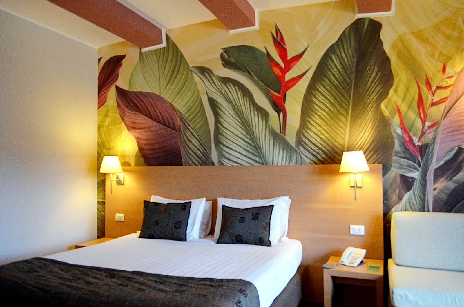 Carta da parati camera hotel  con foglie grandi verdi